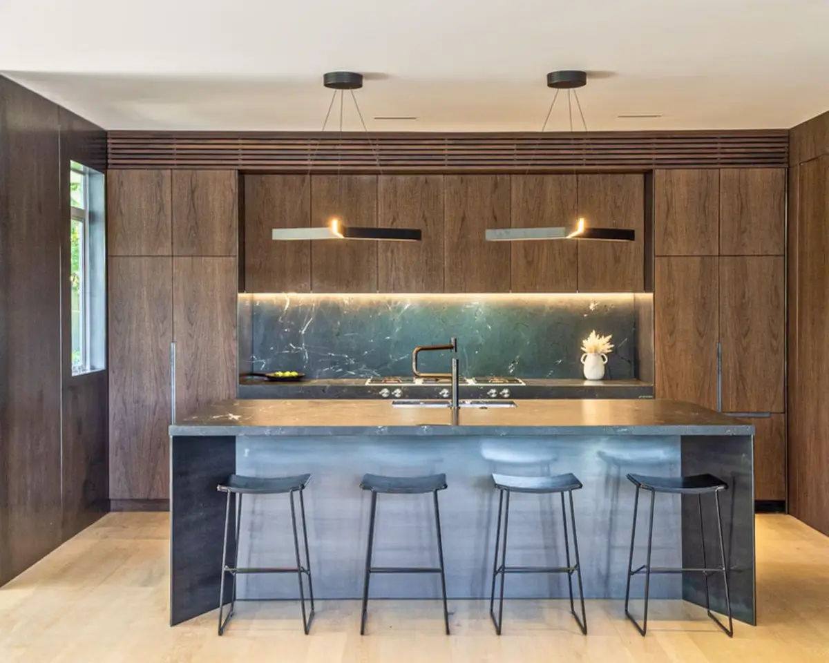 Wide view of DBJ Furniture’s Walnut Wonderland kitchen featuring seamless walnut cabinetry, integrated Tekton veneer edging, and a dark stone island.