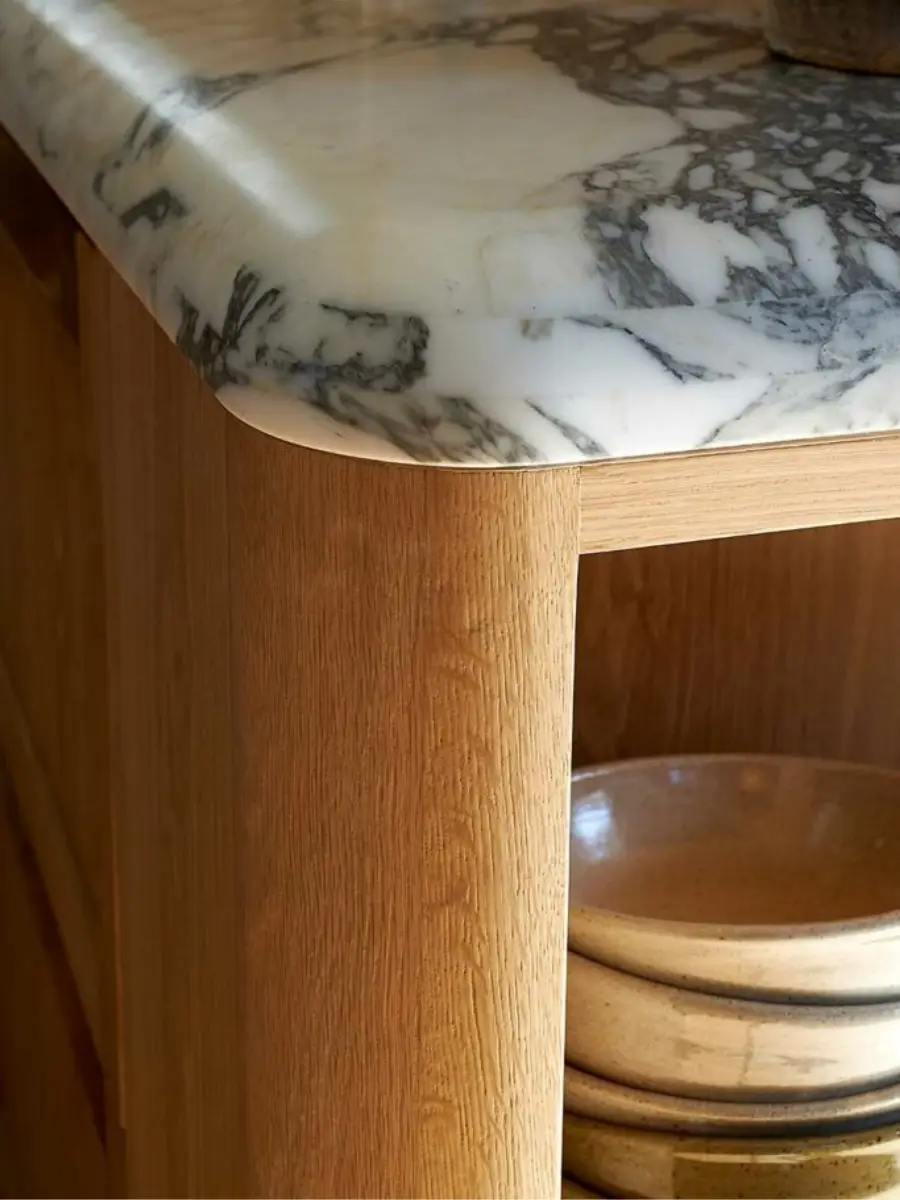 Rounded edge detail of a marble benchtop meeting a vertical oak veneer panel, showcasing DBJ Furniture’s precision joinery and multi-layer veneer craftsmanship.
